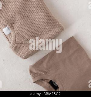 Zwei modische Strickpullover in Beige auf weißem Hintergrund. Stylischer Strickpullover aus Baumwolle für Herren und Vintage-Strickjacke. Trendige Strickmode Für Herren. Stockfoto