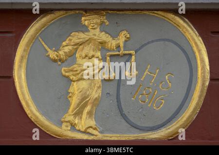Goldenes Relief der Justitia mit Augen und einer Waage in der Hand über dem Eingang zum heutigen Hotel Adler, Tangermuende, Sachsen Stockfoto