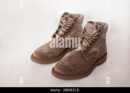 Nahaufnahme Eines Paar stilvolle, beige Luxusstiefel aus Wildleder isoliert auf weißem Hintergrund im Studio. Neue modische Frühjahrskollektion von Herrenschuhen. Stockfoto