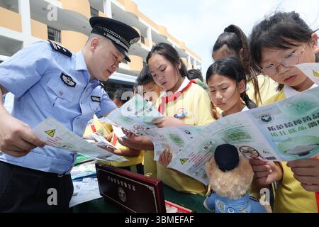 Peking, Chinas Provinz Zhejiang. Juni 2025. Ein Polizist erklärt den Schülern einer Schule im Daishan County der Stadt Zhoushan in der ostchinesischen Provinz Zhejiang, 25. Juni 2025, die Gefahr von Betäubungsmitteln. Der 26. Juni dieses Jahres ist der 38. Internationale Tag gegen Drogenmissbrauch und illegalen Handel. An vielen Orten in China wurden Publizitäts- und Aufklärungsaktivitäten durchgeführt, um das Bewusstsein für Drogenbekämpfung zu fördern. Quelle: Zou Xunyong/Xinhua/Alamy Live News Stockfoto