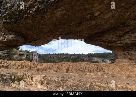 Erodierte Felsformationen bilden einen natürlichen Bogen in der ciudad encantada, cuenca, spanien, mit bewölktem Himmel Stockfoto