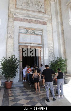 Menschenmassen gehen durch die heiligen Pforten (Porta Santa) der Archbasilika San Giovanni in Laterano in Rom Italien. Die Türen werden nur alle 25 Jahre im Rahmen des Jubiläums in Rom geöffnet. Stockfoto
