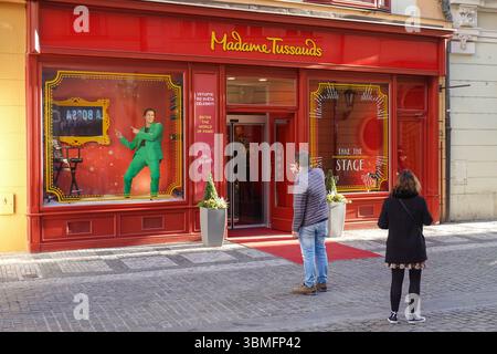 Prag, Tschechische Republik. Mai 2025. Besucher stehen am 9. Mai 2025 vor dem Eingang des Madame Tussauds Wachsmuseums in Prag, Tschechische Republik. Die rote Fassade lädt Touristen ein, „in die Welt der Berühmtheit einzutauchen“ und Fotos mit Werbeanzeigen zu machen. (Foto: Michael Nguyen/NurPhoto) Credit: NurPhoto SRL/Alamy Live News Stockfoto