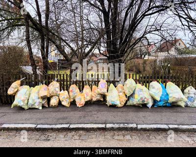 Kaufbeuren, Deutschland. Januar 2025. Zahlreiche Müllsäcke, die neben einem Mülltonnen und einem Holzzaun platziert wurden und Themen der Abfallwirtschaft und der städtischen Sauberkeit transportieren, sammelten am 28. Januar 2025 Plastikmüll in Kaufbeuren, Bayern, Allgäu. Fotograf: ddp Images/STAR-Images Credit: ddp Media GmbH/Alamy Live News Stockfoto