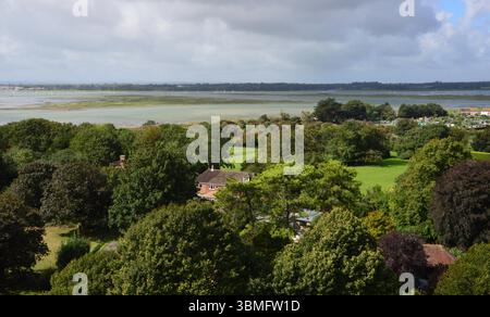 Ein malerischer Blick vom Turm von Portchester Castle aus, mit Blick auf die üppige grüne Landschaft und die Wattflächen von Portsmouth Harbour, Hampshire, England. Stockfoto