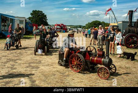 Die Besucher genießen einen Sommertag auf einer Messe für Vintage-Dampfmaschinen, auf der Traktoren und Motoren in ländlicher Umgebung ausgestellt werden Stockfoto