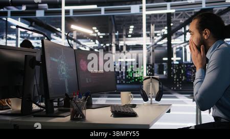 Mitarbeiter, der Hilfe vom Manager anfordert, um gehackte Gerätesysteme zu reparieren. Gestresste Rechenzentrumsadministratoren reagieren auf Spyware-Popup auf dem Computerbildschirm, starten das Notfallprotokoll, Kamera A Stockfoto