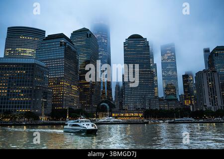 New York City Skyline bei Nacht - die Battery River Tour - New York Gebäude Wolkenkratzer Lichter am Abend auf dem East River - Stockfoto
