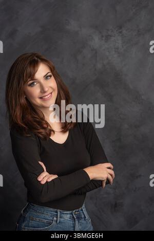 Lächelnde, selbstbewusste Frau mit überkreuzten Armen, Porträt Stockfoto
