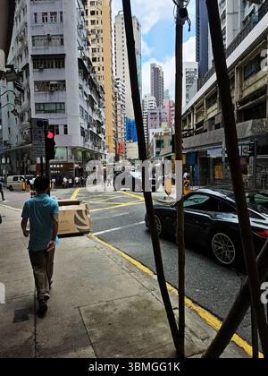 Geschäftige Kreuzung Wan Chai mit Luxusauto und Fußgängerzone Stockfoto