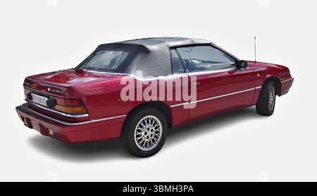 Klassisches rotes Chrysler LeBaron Cabriolet mit teilweise geöffnetem Verdeck, das Vintage-Charme versprüht Stockfoto