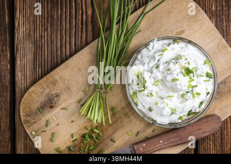 Schüssel mit Kräuter-Quark (detaillierte Nahaufnahme gedreht) auf hölzernen Hintergrund Stockfoto