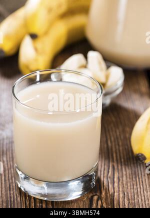 Frisch gemacht Bananensaft in einem Glas (auf hölzernen Hintergrund) Stockfoto