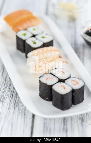 Etwas frisch zubereitetes Sushi auf einem Holztisch (selektiver Fokus, Nahaufnahme) Stockfoto