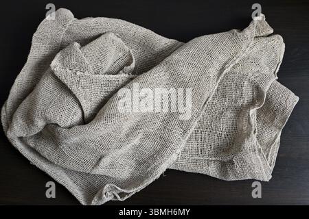 Rauer natürlicher Materialsack auf dunklem hölzernem Hintergrund Stockfoto
