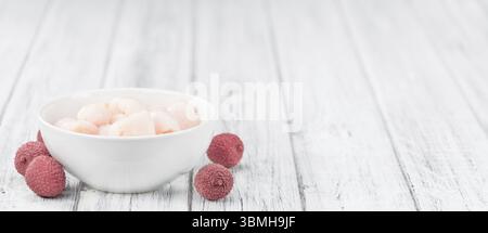 Erhaltene Lichees auf einem alten Holztisch als detaillierte Nahaufnahme (selektiver Fokus) Stockfoto