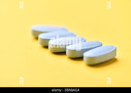 Multivitamintabletten auf hellem Papierhintergrund. Nahaufnahme. Kopierbereich Stockfoto