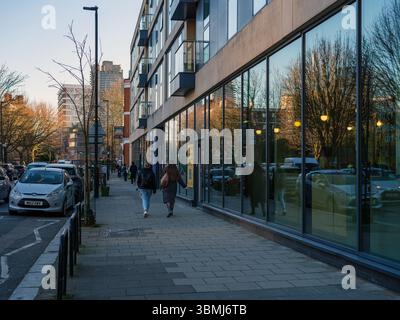 Vereinigtes Königreich, London, 4. Juli 2025. Blick auf die Straße auf ein modernes Wohn- und Geschäftsgebäude in London mit Fußgängern, die an Glas entlang laufen Stockfoto