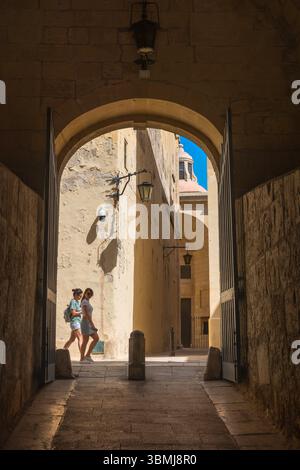 Altstadt von Mdina, Blick auf zwei junge weibliche Touristen, die die malerischen Straßen der historischen ummauerten Stadt Mdina, Malta, erkunden Stockfoto