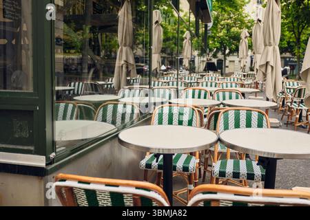 Leere pariser Bistrotische und -Stühle warten auf Gäste Stockfoto