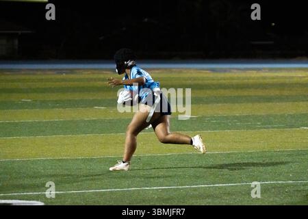 Flaggenfußballspieler dreht das Feld nach einem Fang in Richtung Endzone und versucht, einen Touchdown für den Teamsieg zu erzielen Stockfoto
