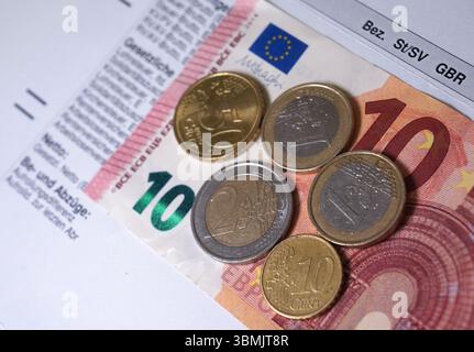 Hamburg, Deutschland. Juni 2025. ILLUSTRATION - Euro- und Cent-Münzen liegen auf einem Lohnbeleg und auf einem 10-Euro-Schein und machen zusammen 14,60 Euro aus. Der Mindestlohn in Deutschland soll zum 1. Januar 2027 in zwei Stufen auf 14,60 Euro steigen. Quelle: Marcus Brandt/dpa/Alamy Live News Stockfoto