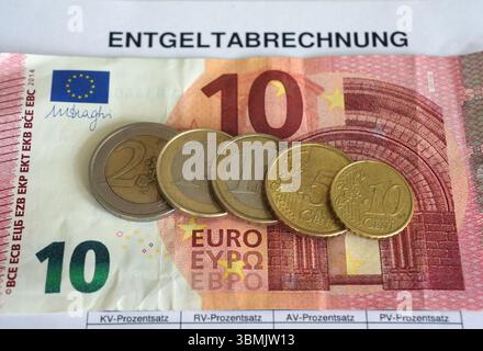Hamburg, Deutschland. Juni 2025. ILLUSTRATION - Euro- und Cent-Münzen liegen auf einem Lohnbeleg und auf einem 10-Euro-Schein und machen zusammen 14,60 Euro aus. Der Mindestlohn in Deutschland soll zum 1. Januar 2027 in zwei Stufen auf 14,60 Euro steigen. Quelle: Marcus Brandt/dpa/Alamy Live News Stockfoto