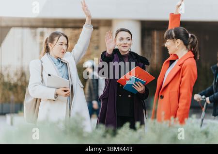 Drei Geschäftsfrauen interagieren im Freien, während sie ein produktives Gespräch führen. Stockfoto
