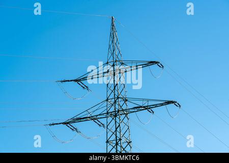 Kammlach, Bayern, Deutschland - 24. Juni 2025: Nahaufnahme eines Hochspannungsmasts mit klaren Linien vor wolkenlosem Himmel *** Detailaufnahme eines Hochspannungsmasts mit klaren Linien vor wolkenlosem Himmel Stockfoto