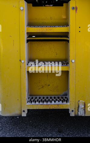 Nahaufnahme von Metallstufen auf gelbem Schwerbau Stockfoto