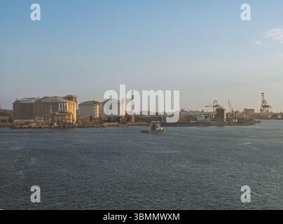 Barcelona, Spanien - 11. Juli 2024: Enagas riesige LNG-Tanks an Kais im Hafen, kleines Schlepper in Bewegung Stockfoto