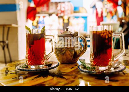 Pfefferminztee im arabischen Stil mit Pinienkernen, serviert mit einer silbernen Teekanne in einem tunesischen Café im Souk in Nabeul, Tunesien Stockfoto