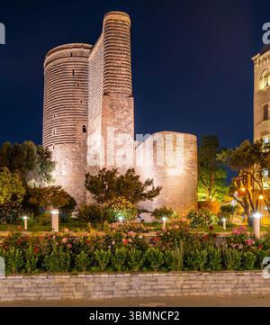 Jungfernturm oder QIZ Qalasi, beleuchtet bei Nacht in Baku, Aserbaidschan, mit einem Garten im Vordergrund Stockfoto
