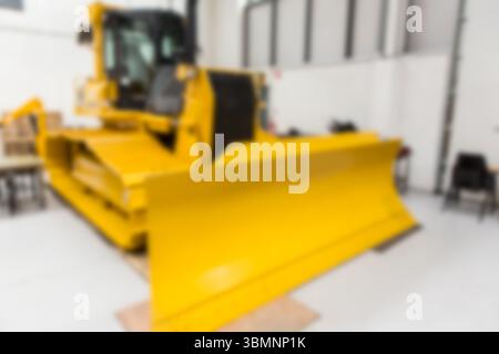 Die flache Bauweise zeigt einen großen gelben Bulldozer, der im Lager mit Stühlen und Kisten sitzt Stockfoto