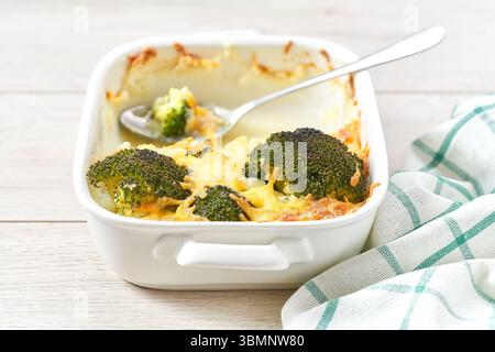 Gebackener Auflauf Brokkoli mit Käse und Sahnesauce in einem weißen Backblech, Nahaufnahme. Stockfoto