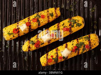 Hausgemachte gegrillte Maiskolben mit schmelzender Butter, Blick von oben. Gegrillter Mais mit Butter. Stockfoto