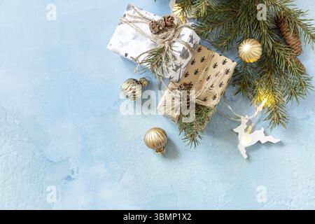 Weihnachtskugeln, Wintertanne mit Geschenkboxen und weihnachtsdekor auf blauem Steingrund. Weihnachts- und Neujahrskonzept. Blick von oben. Co Stockfoto