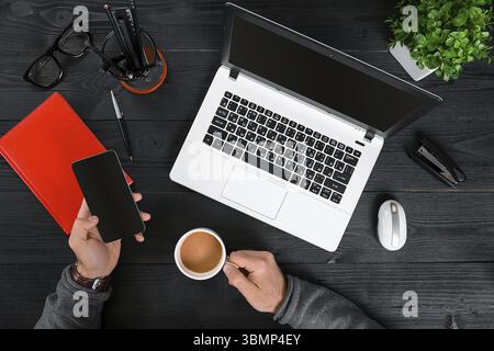 Hipster schwarz Holz Desktop Draufsicht, männliche Hände tippen auf einem Laptop. Draufsicht. Speicherplatz kopieren Stockfoto