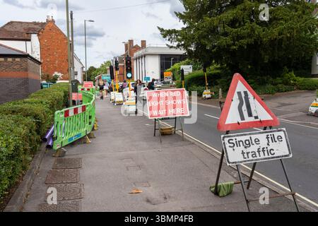 Fußweg geschlossen und vorübergehende Fußgängerüberquerung mit einzelnem Verkehrswarnschild und wenn die rote Ampel erscheint, warten Sie hier auf Baustellen, Großbritannien Stockfoto