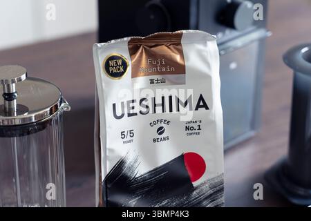 Paket mit dunkel gerösteten Kaffeebohnen Fuji Mountain Ueshima auf einer Küchenoberfläche mit Kaffeezubereiter, die als Japans Nummer eins Kaffeemarke bezeichnet wird Stockfoto