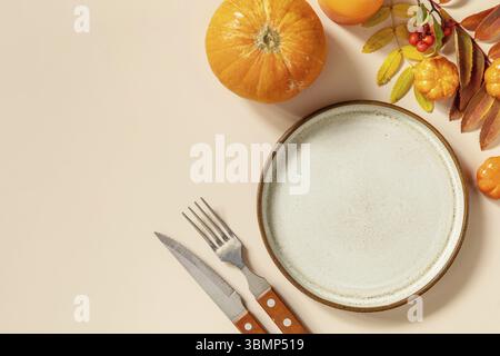 Herbst Halloween oder Thanksgiving Tagestisch Einstellung. Herbsthintergrund mit leerem Teller, Besteck, Kürbissen. Thanksgiving Hintergrund Nachbildung. Ansicht fr Stockfoto