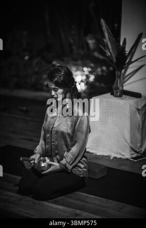 Schwarz-weiß-Porträt einer Frau mit tibetischer Schüssel drinnen Stockfoto