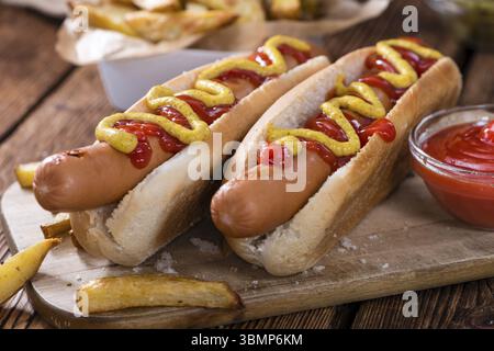 Klassischen Hot Dog (Nahaufnahme) auf hölzernen Hintergrund mit Ketchup und Senf Stockfoto