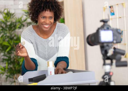 Eine Frau filmt sich selbst und restauriert einen Schrank für einen Blog Stockfoto