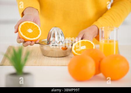 Zugeschnittene Ansicht einer Frau mit orangefarbener Quetschpresse Stockfoto