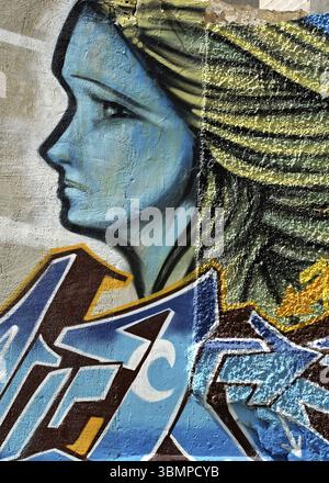 Blaues Graffiti-Porträt einer Frau mit gelbem Haar, die nach links schaut, gemalt auf einer Betonwand Stockfoto