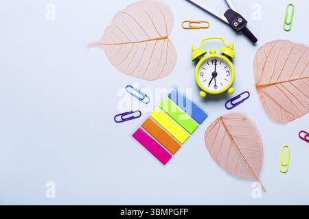 Schulbedarf und orangefarbene Blätter auf blauem Hintergrund. Back-to-School-Konzept Stockfoto