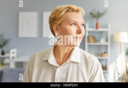 Porträt einer älteren älteren Frau, die legere Kleidung trägt und zu Hause zur Seite blickt. Stockfoto