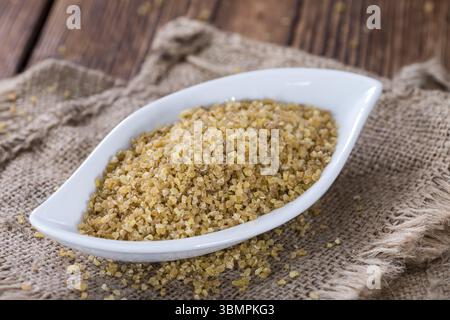 Portion rohen Bulgur (Nahaufnahme) auf hölzernen Hintergrund Stockfoto