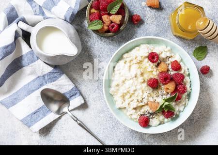 Haferbrei in einer Keramikschale, dekoriert mit frischen Beeren, Himbeeren und Chiasamen, serviert mit Honig. Gesunde Ernährung Frühstück. Blick von oben Stockfoto